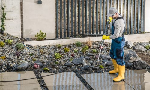 Man Pressure Washing Concrete Tiles